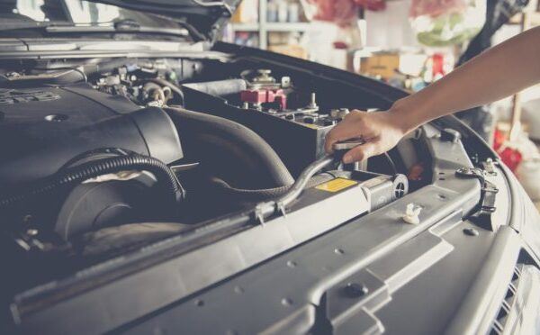 Mechanic working on a car engine inside the repair shop.