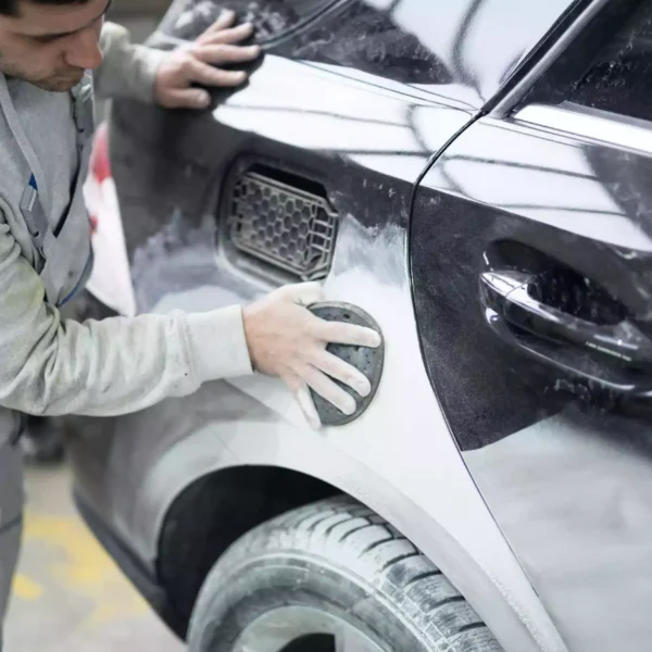 A technician preparing a car for painting at Network Auto Body’s advanced workshop.